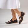 Pair of brown leather shoes worn by someone in a dress